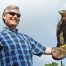 Smiling man holding eagle